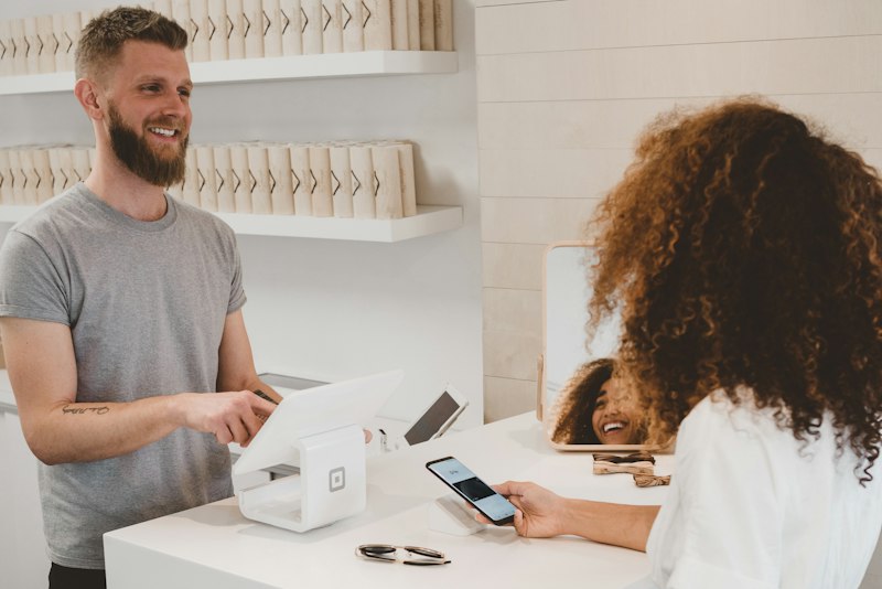 Shop owner handing over a parcel to a customer